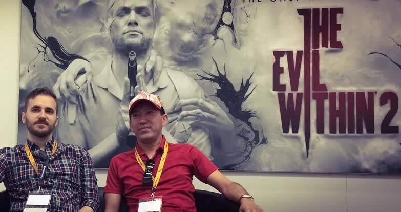 John Johanas e Shinji Mikami na frente do cartaz de The Evil Within 2