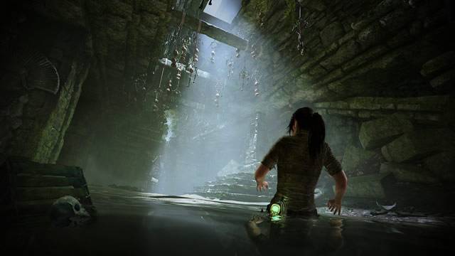 Lara caminhando na água dentro de uma tumba Shadow of the Tomb Raider